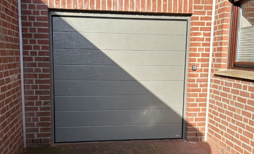 Weißes Garagentor an einem Haus in Ziegeloptik