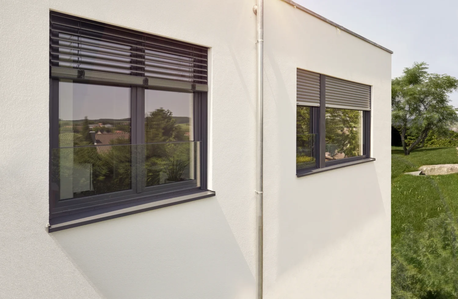 Moderne Fenster mit Jalousien an einem hellen Gebäude